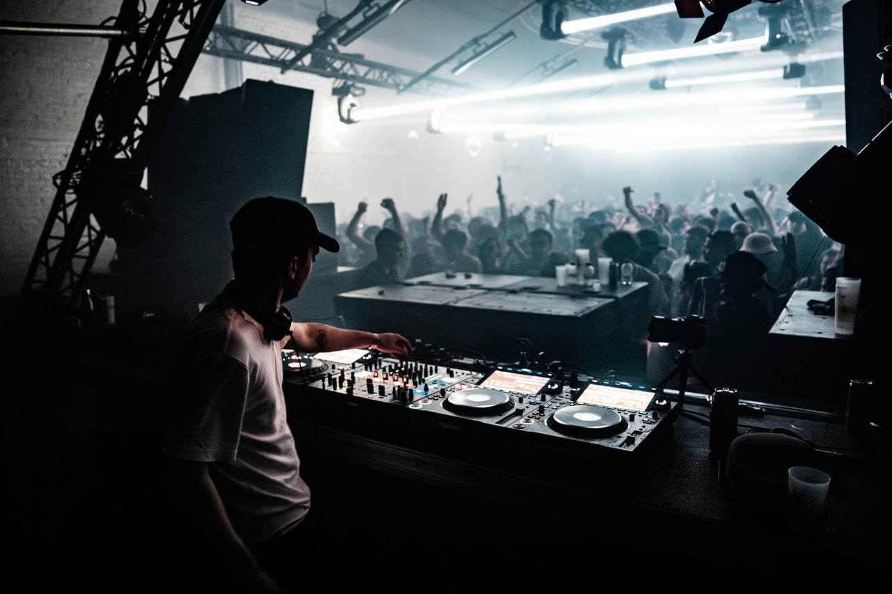 Le DJ en cabine, tubes et contres bleus sur la foule